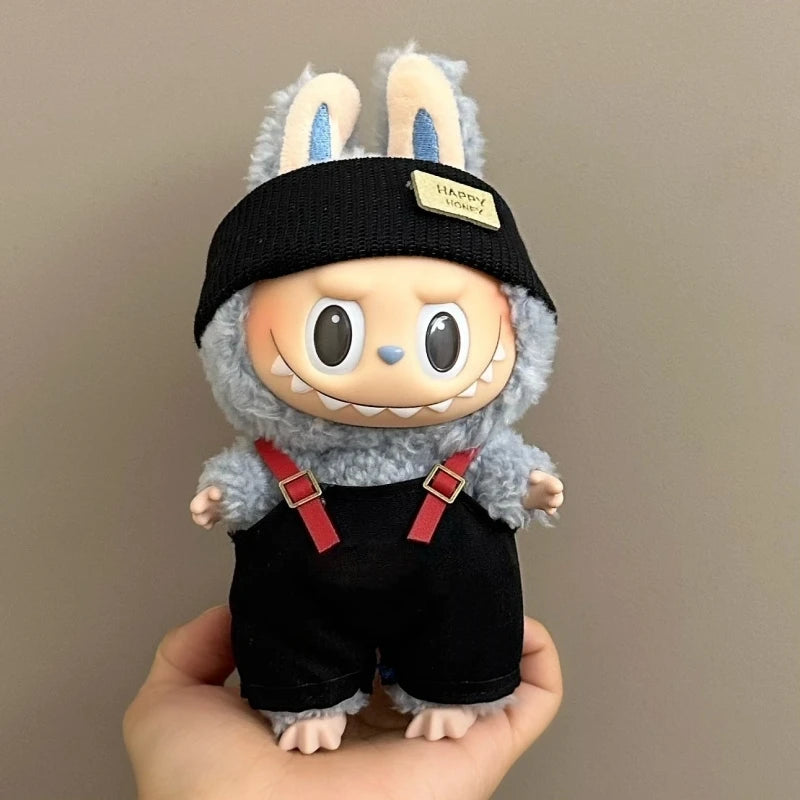 Toy figure with bunny ears and a black hat held in a hand against a plain background