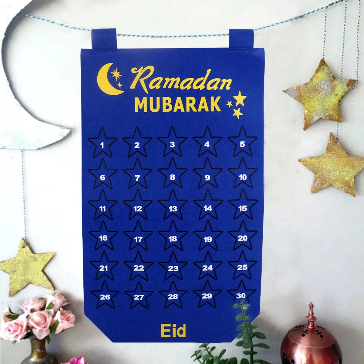 Blue Ramadan Mubarak calendar with stars and numbers on a white background with decorative elements.