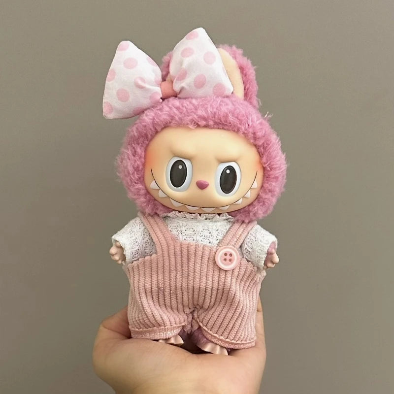 Toy figure with pink hair and outfit held against a plain background